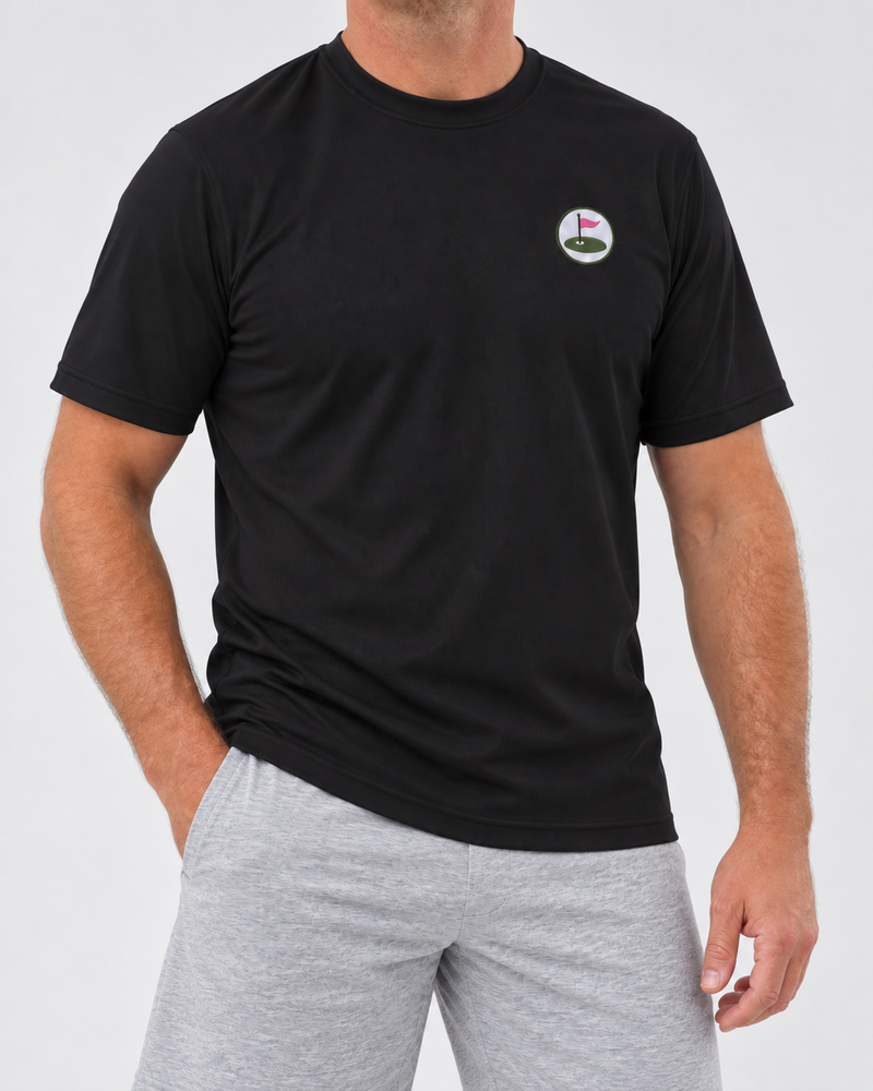 Model wearing the black Seabury performance tee with embroidered chest roundel and light grey marl shorts.