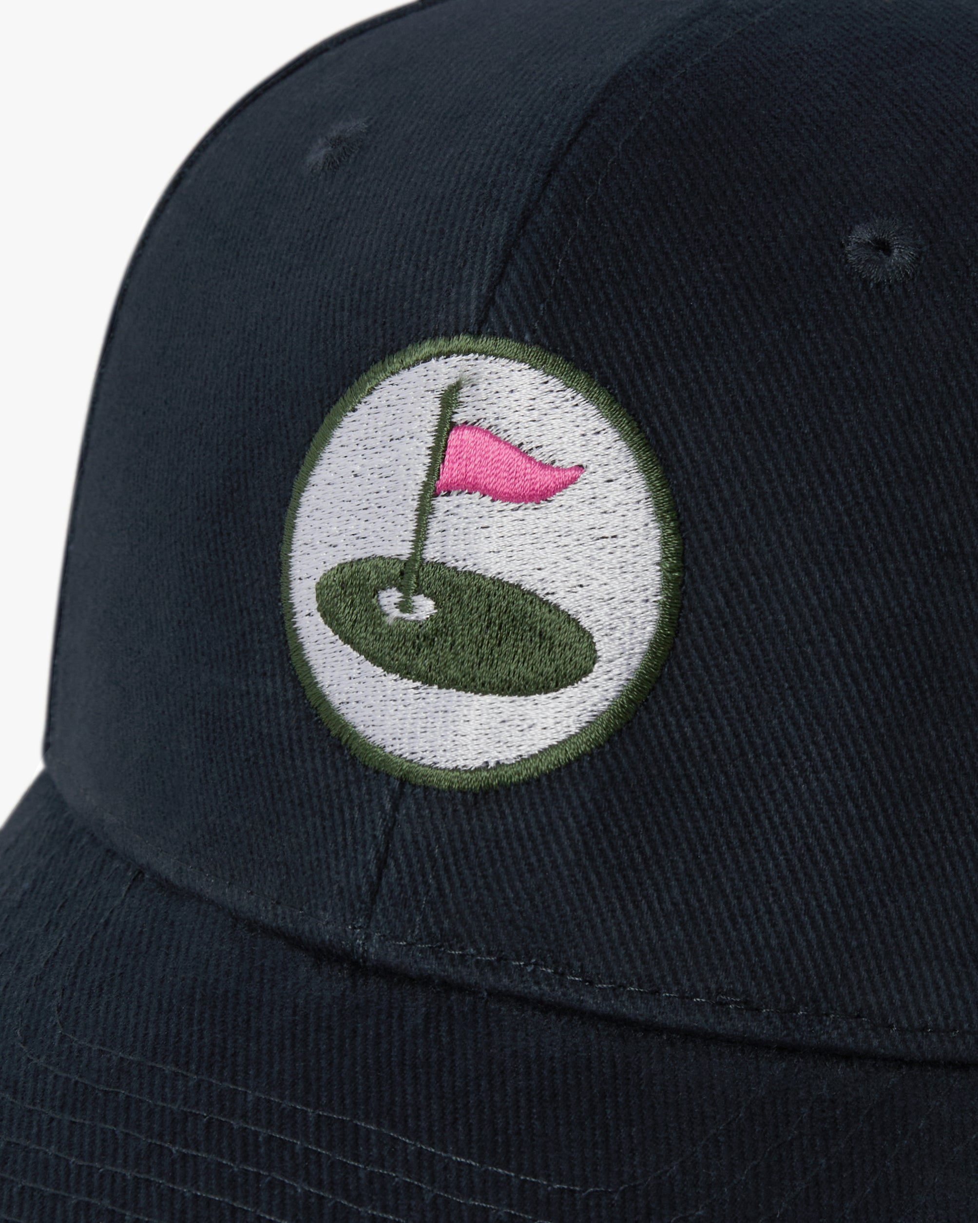 Navy golf cap featuring a pink flag on a white background.